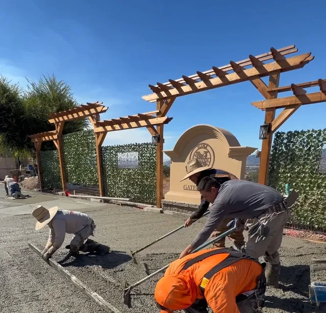 Crew screeding concrete at a pergola entry
