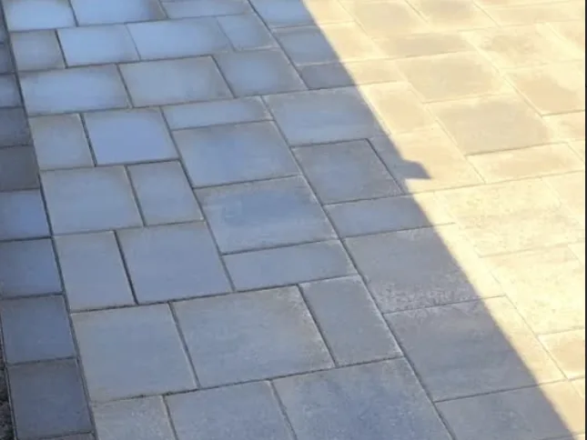 Grey paver walkway with a dark border course